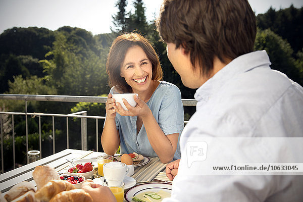Glückliches Paar beim Frühstück auf dem Balkon
