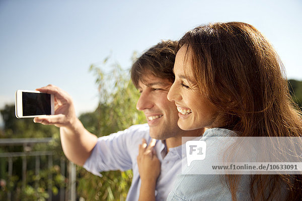 Glückliches Paar im Freien mit einem Selfie