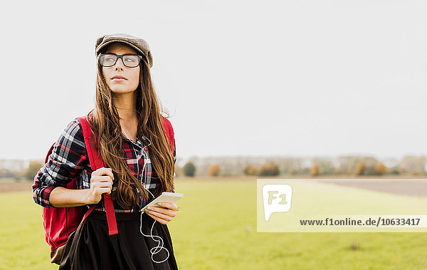 Young woman with backpack and portable device in the countryside