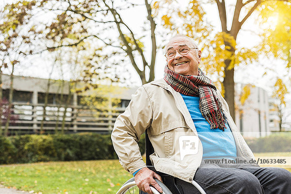 Smiling senior man in wheelchair outdoors