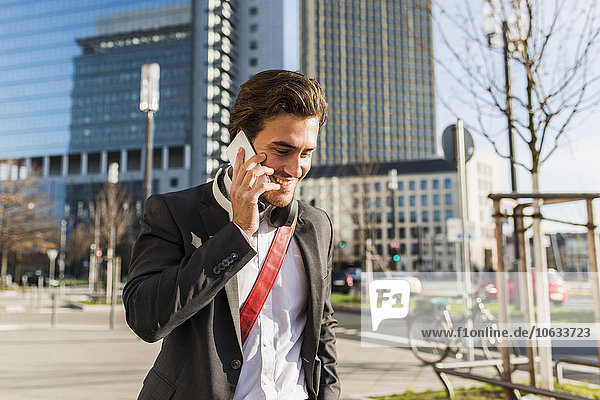 Deutschland  Frankfurt  Junge Geschäftsleute  die mit dem Handy durch die Stadt laufen