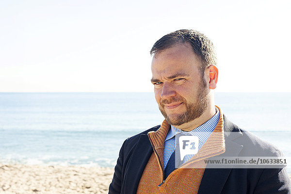 Spain  Barcelona  portrait of businessman in front of the beach