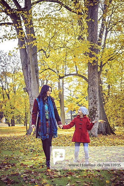 Mutter und Tochter beim Spaziergang im Herbstpark