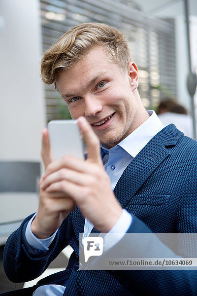 Portrait of young businessman with cell phone