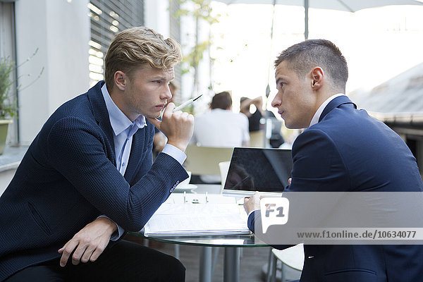 Two businessmen thinking about file