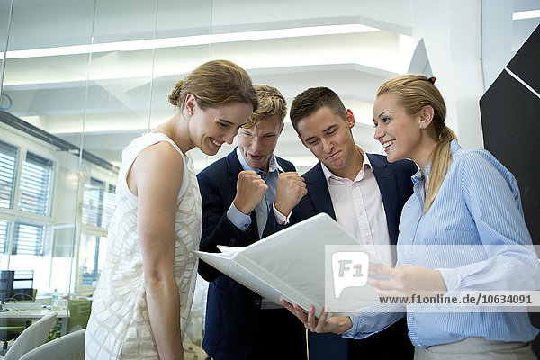 Successful business team in office looking at folder