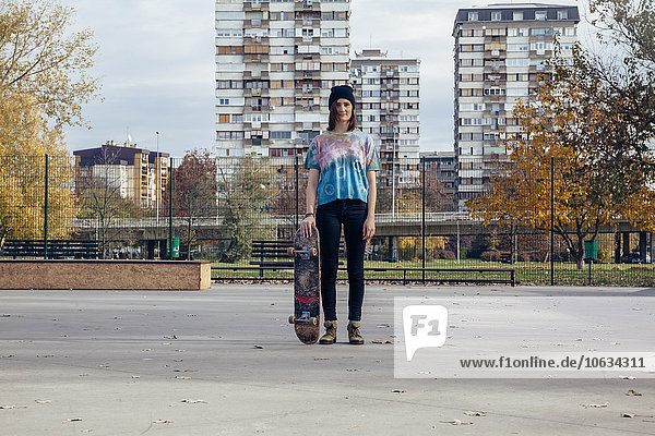 Portrait einer jungen Frau mit Skateboard