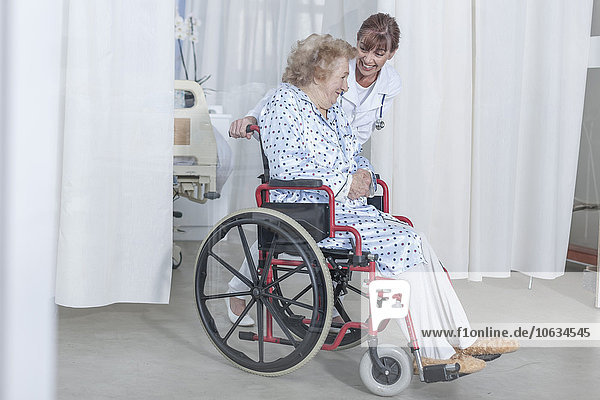Arzt und älterer Patient im Rollstuhl