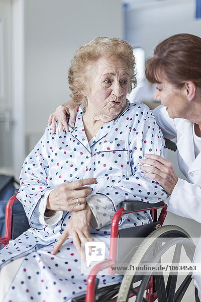 Doctor caring for elderly patient in wheelchair