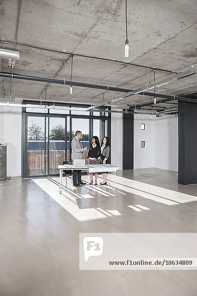 Businesspeople standing and talking in new open office