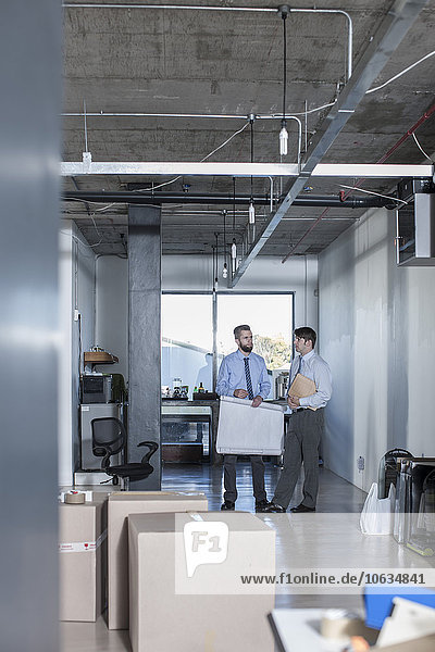 Two businessmen standing and talking in new office