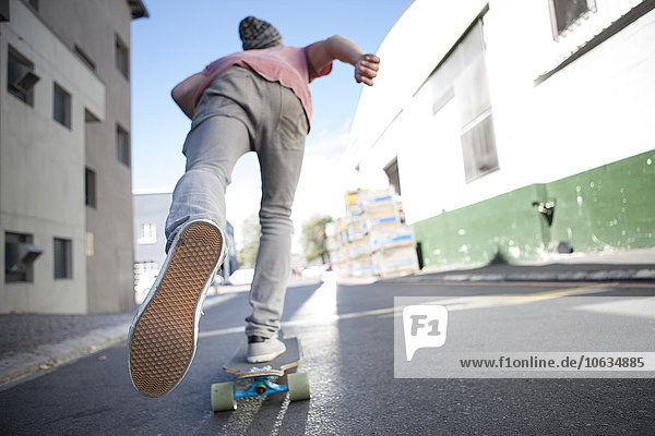 Rückansicht eines Skateboardfahrers auf der Straße