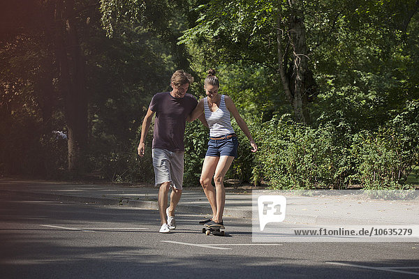 Young man helping woman to skating