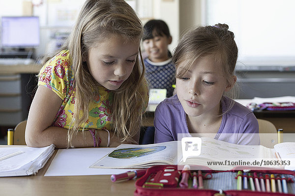Mädchen lesen Buch im Klassenzimmer