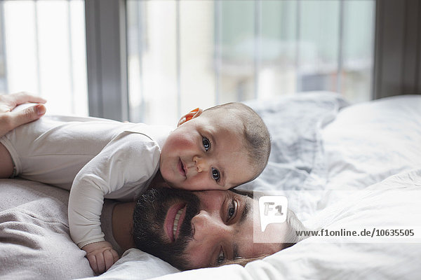 Porträt des liebenden Vaters mit im Bett liegendem Mädchen