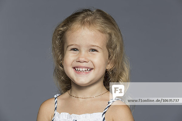 Porträt des süßen Mädchens vor grauem Hintergrund
