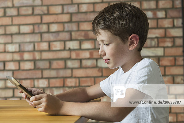 Seitenansicht des Jungen mit digitalem Tablett zu Hause