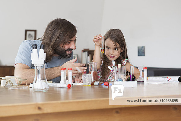Vater und Tochter beim wissenschaftlichen Experiment zu Hause