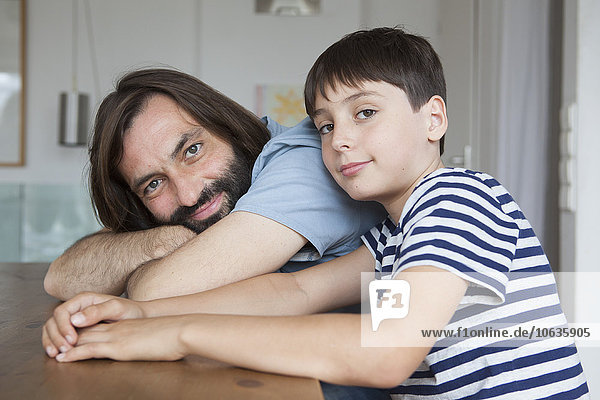 Porträt von Vater und Sohn am Tisch sitzend im Haus