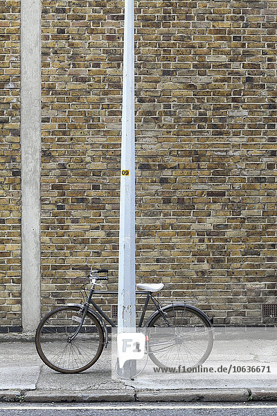 Fahrrad an der Stange auf dem Bürgersteig verriegelt