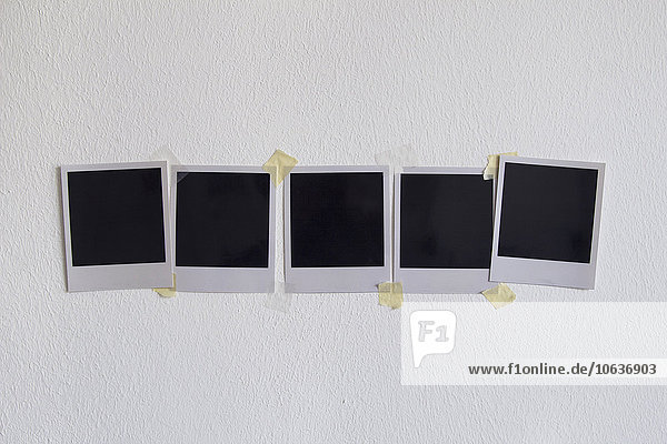 Leere Sofortbilder auf weißer Wand geklebt