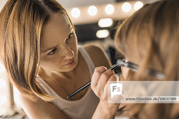 Künstlerin beim Schminken am Model