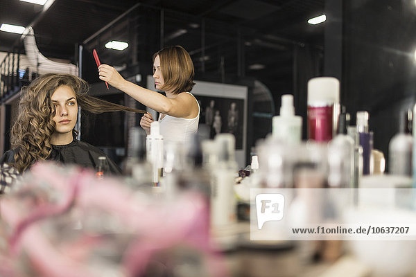 Friseur beim Kämmen der Haare von Models