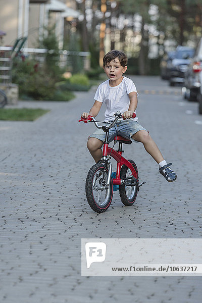 Junge fährt Fahrrad auf der Straße