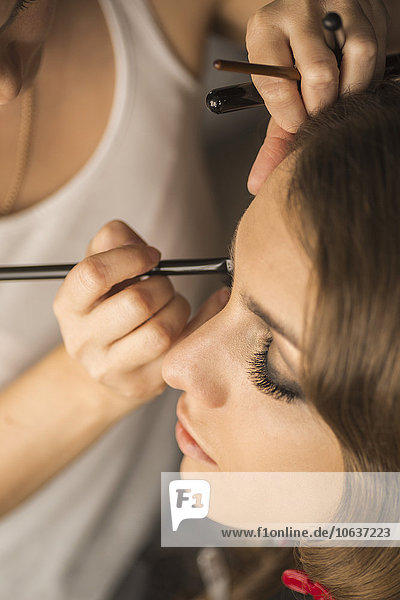 Hochwinkelansicht der Frau beim Auftragen des Augen-Make-ups auf das Mode-Modell