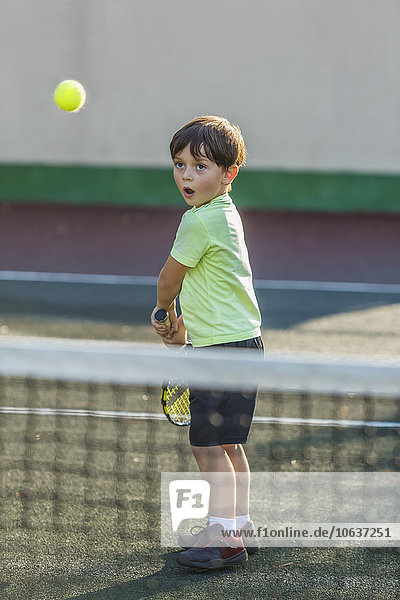 Junge beim Tennisspielen auf dem Platz