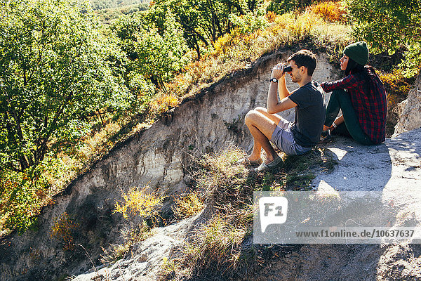 High angle view of friends sitting on mountain at forest