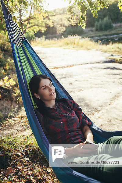 Young hiker resting on hammock in forest