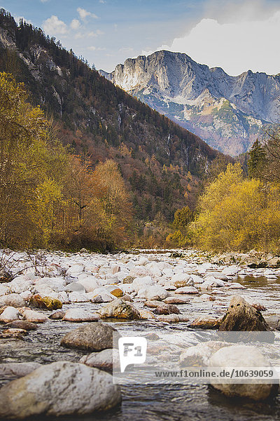 Steine am Fluss gegen felsige Berge im Herbst