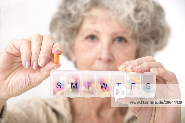 Woman holding pill and pill container