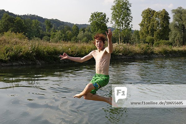 Junge  Teenager springt ins Wasser in einem Fluss  Oberbayern  Bayern  Deutschland  Europa