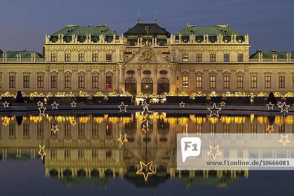 Christmas lights with Christmas Market in front of Belvedere Palace  reflection in the lake  Vienna  Austria  Europe