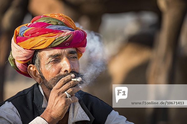 Portrait of Rajasthani man with turban smoking a cigarette  Pushkar  Rajasthan  India  Asia