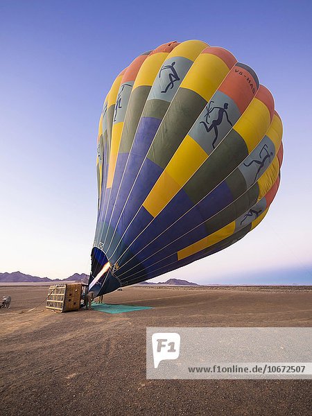 Heißluftballon wird aufgeheizt  Kulala Wilderness Reserve  Namib-Wüste  Tsarisberge  Region Hardap  Namibia  Afrika