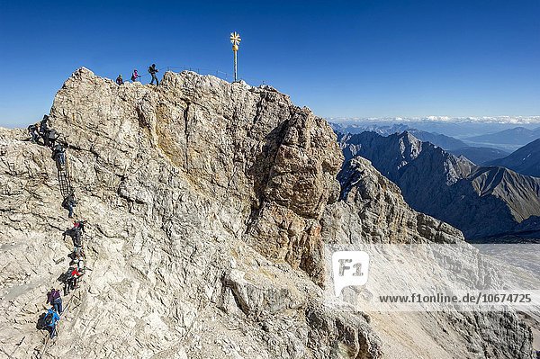 Touristen am Gipfelkreuz der Zugspitze  Ausblick nach Tirol  Garmisch-Partenkirchen  Wettersteingebirge  Alpen  Oberbayern  Bayern  Deutschland  Europa