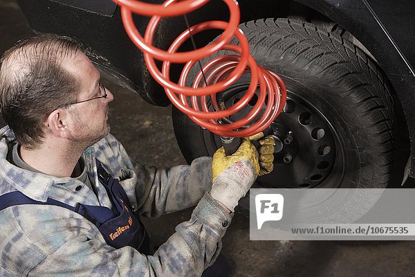 Reifenwerkstatt  Automechaniker  Kontrolle und Reifenwechsel von Sommerreifen und Winterreifen an PKW  Düsseldorf  Nordrhein-Westfalen  Deutschland  Europa