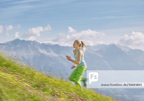 Junge Frau  20-25 Jahre  läuft über eine Bergwiese bergauf  Berglauf  Mutterer Alm  Innsbruck  Tirol  Österreich  Europa