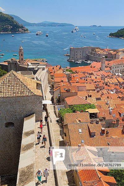 Dubrovnik  Dubrovnik-Neretva County  Croatia. View over rooftops of the old town from the Minceta Tower. Boats in the Old Port. Cruise boats under way. The old city of Dubrovnik is a UNESCO World Heritage Site.