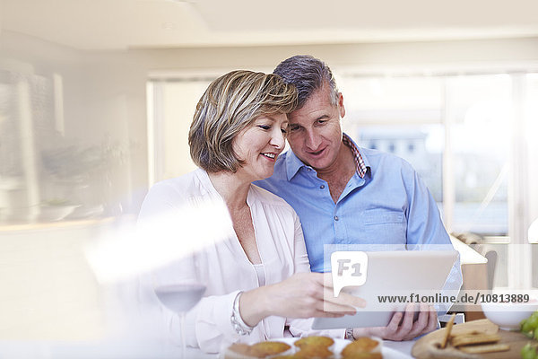 Paar mit digitalem Tablett in der Küche