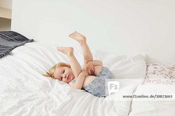 Portrait of female toddler playing on bed