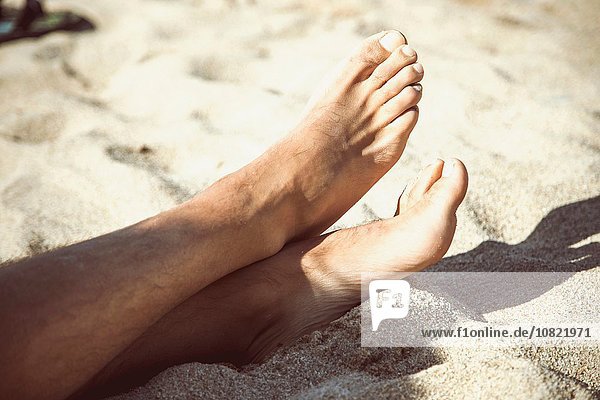 Cropped view of bare feet on sandy beach  Costa Paradiso  Sardinia  Italy