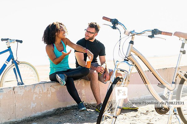 Couple sitting on wall  taking a break  bicycles beside them