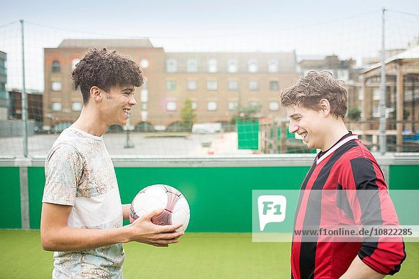 Zwei junge Männer spielen Fußball auf dem Stadtfußballplatz