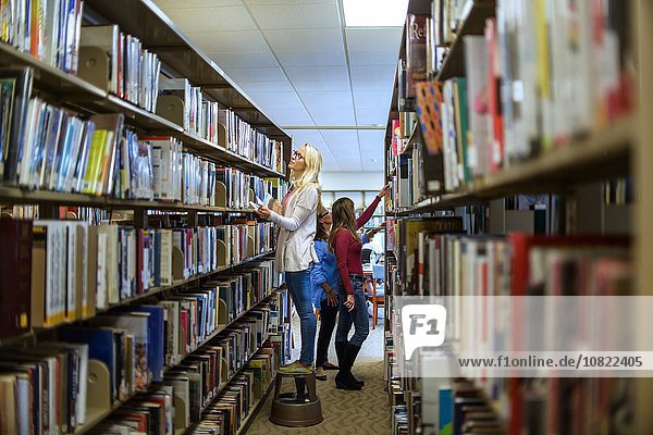 Women searching for books in library