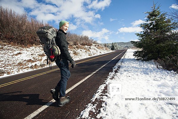 Junge männliche Wanderer auf der Landstraße in verschneiter Landschaft  Ashland  Oregon  USA
