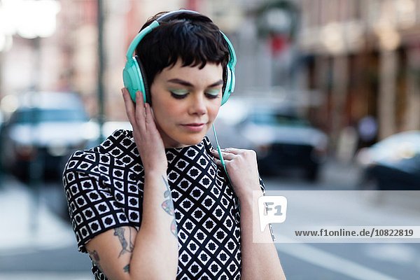 Mittlere erwachsene Frau  Retro-Kleidung  Kopfhörer tragend  Outdoor